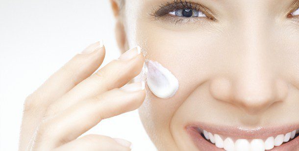 Close Up of Female Face Applying Lotion to Cheek Close Up of Female Face Applying Lotion to Cheek