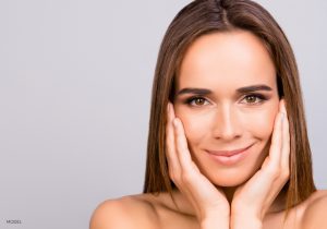 Young Woman with a Sculpted Nose Framing Her Face in her Hands